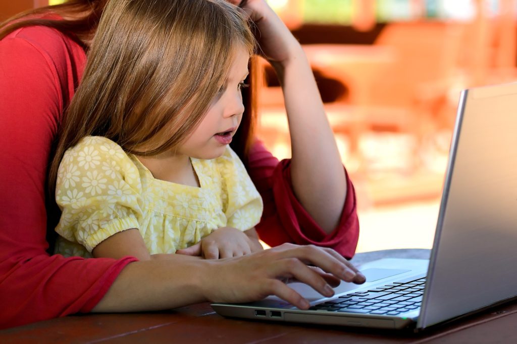 Young girl and mother looking at computer.