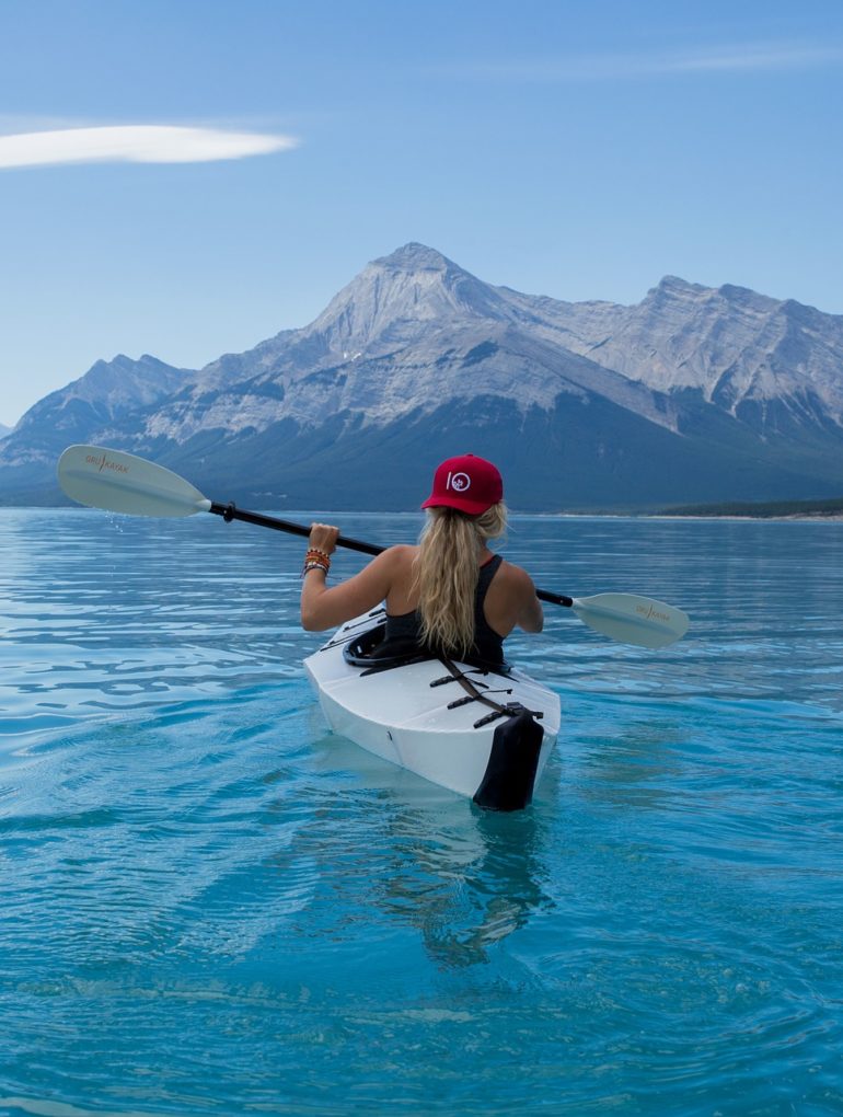 Woman rowing a kayak on a mountain lake