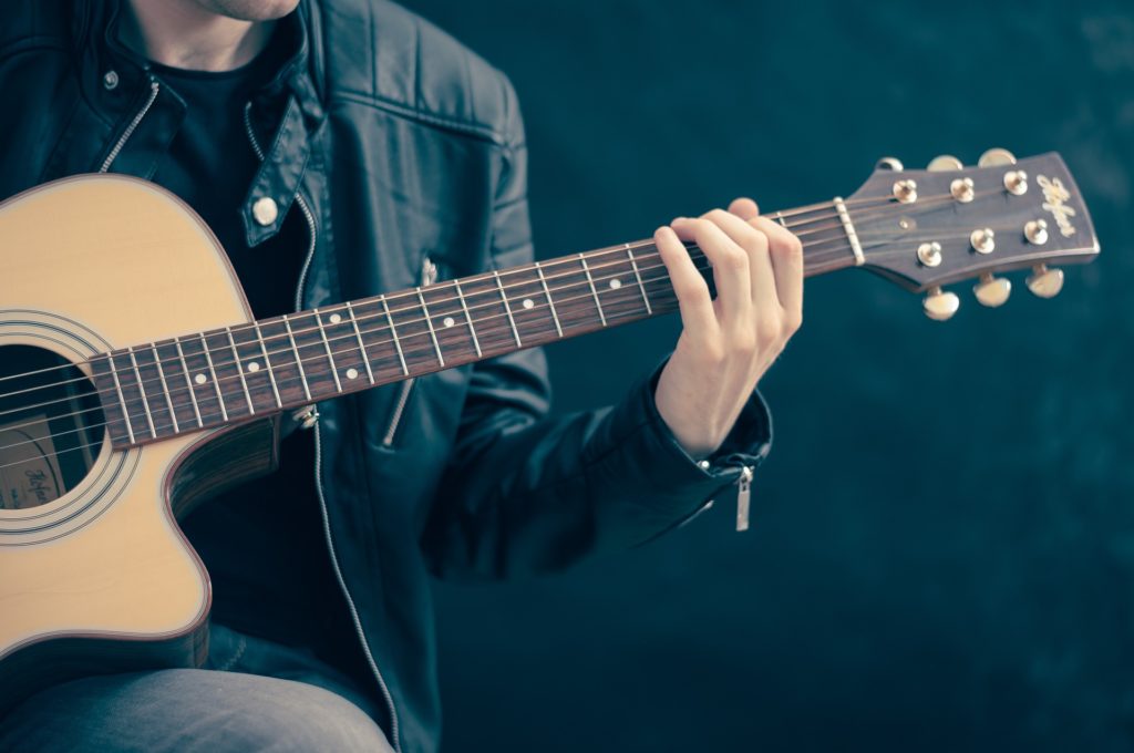 close up of man playing guitar